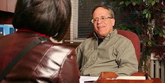 A man speaking to a woman across a desk